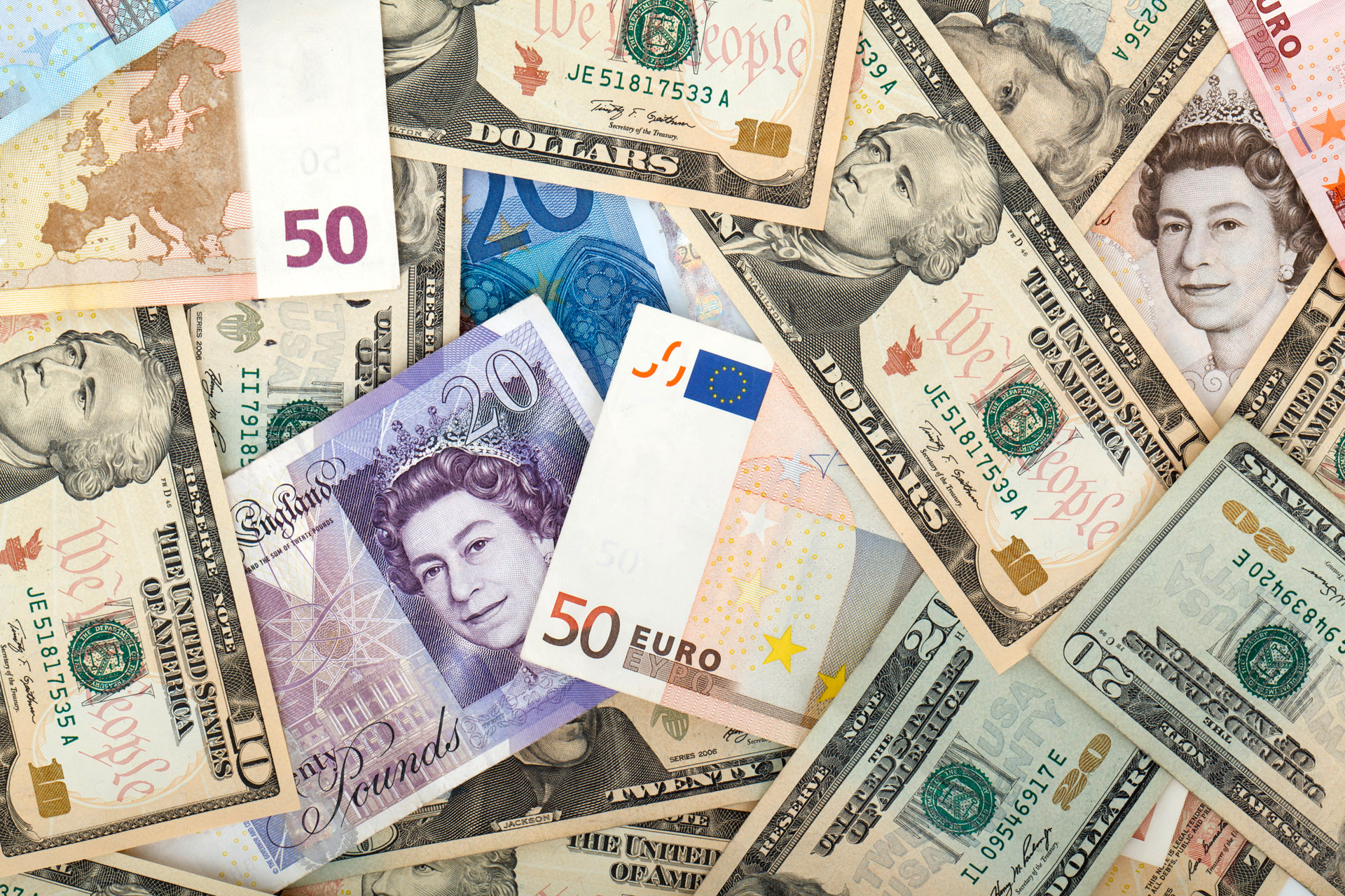 Close up image of various bills including dollars, pounds, and euros.