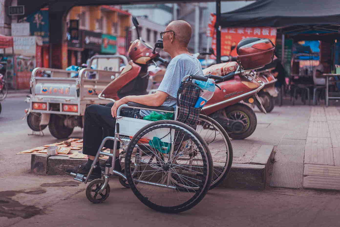 a man in a wheelchair on the sidewalk